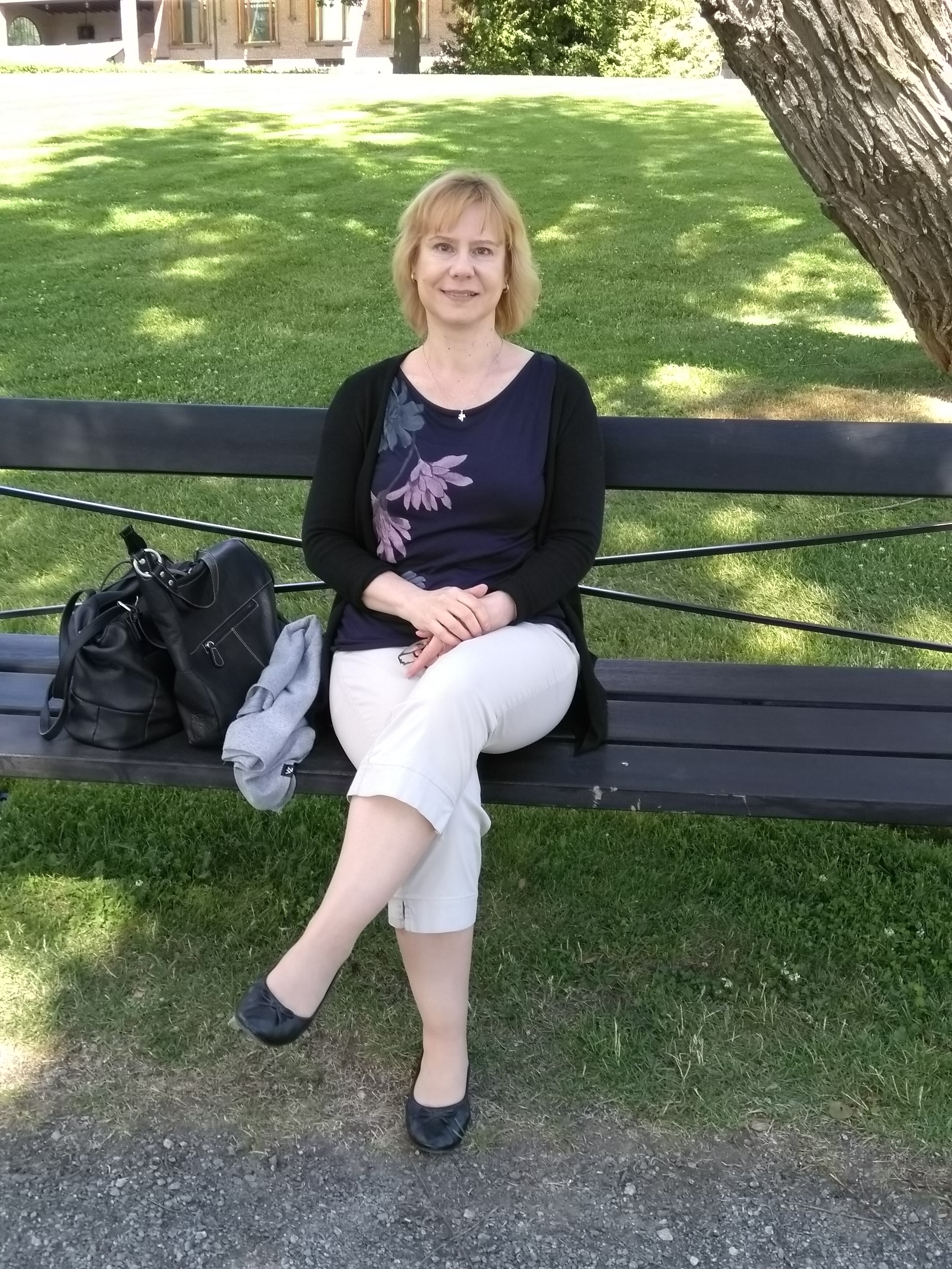 Marita Ahvenjärvi istuu puistonpenkillä
